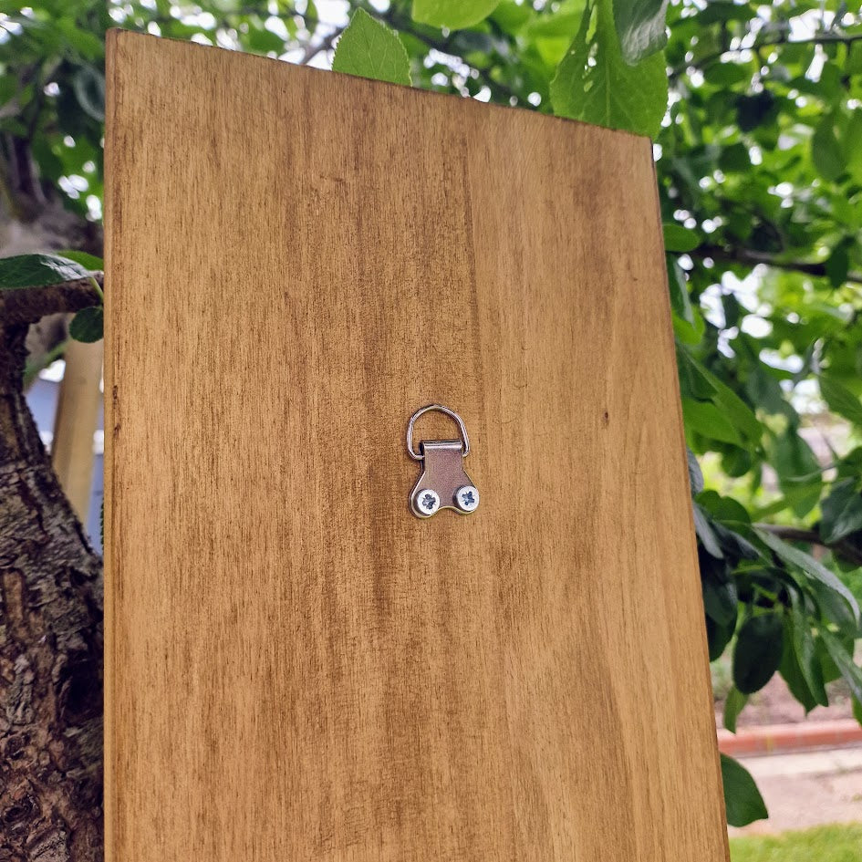 Hand-painted chakra wall art on natural wood, featuring seven chakra symbols in vibrant colours