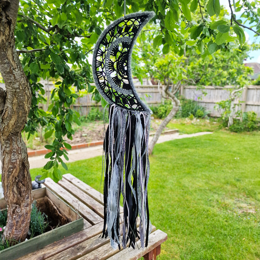 Handmade crochet Moon dreamcatcher with black and silver/grey fringe, perfect for boho wall décor and nursery spaces.