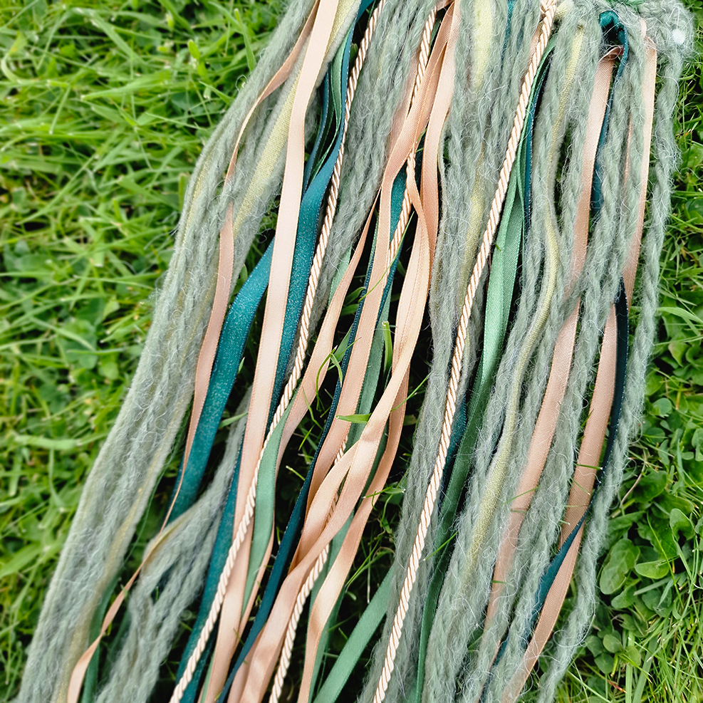 Handmade crochet Moon dreamcatcher with green and gold ribbons and fringe, perfect for boho wall décor and nursery spaces.