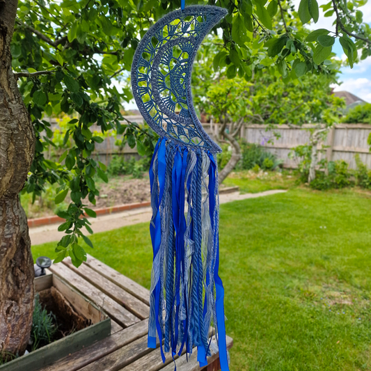 Handmade crochet Moon dreamcatcher with blue and silver ribbons and fringe, perfect for boho wall décor and nursery spaces.
