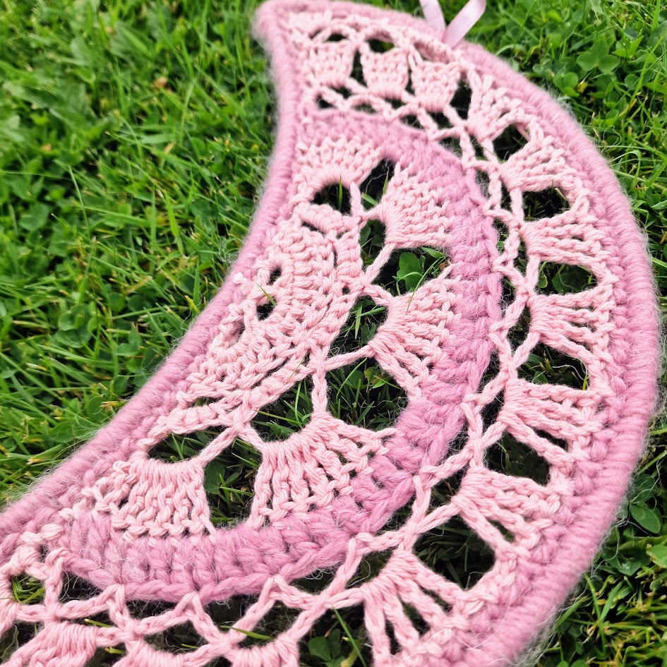 Handmade crochet Moon dreamcatcher with pink ribbons and fringe, perfect for boho wall decor and nursery spaces.