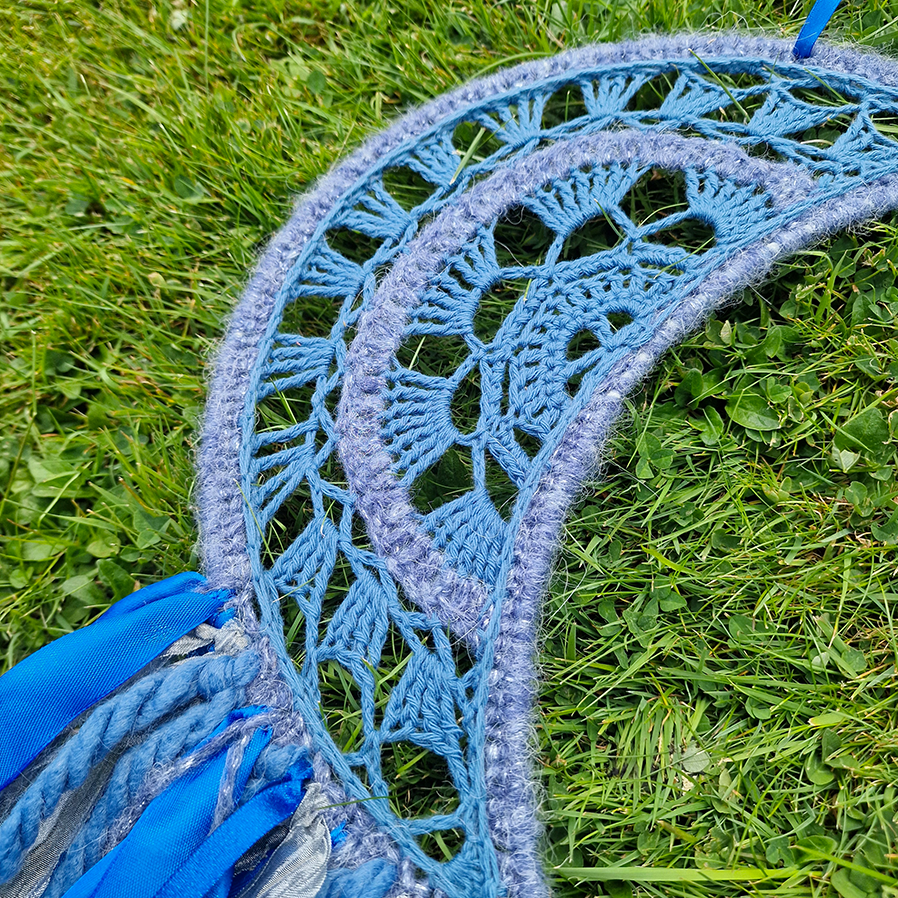 Handmade crochet Moon dreamcatcher with blue and silver ribbons and fringe, perfect for boho wall décor and nursery spaces.