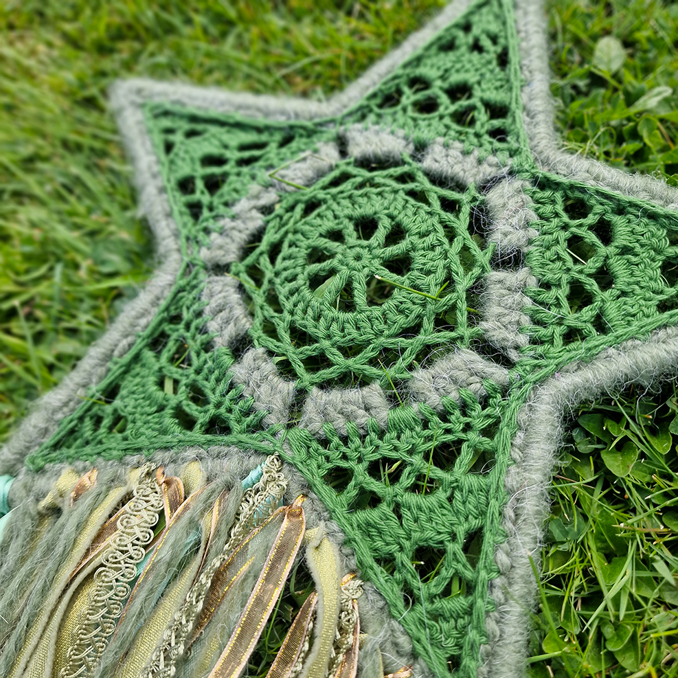 Handmade crochet star dreamcatcher with green and gold and fringe, perfect for boho wall décor and nursery spaces.