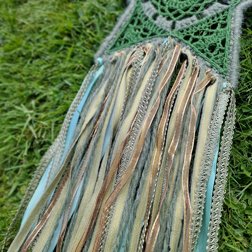 Handmade crochet star dreamcatcher with green and gold and fringe, perfect for boho wall décor and nursery spaces.