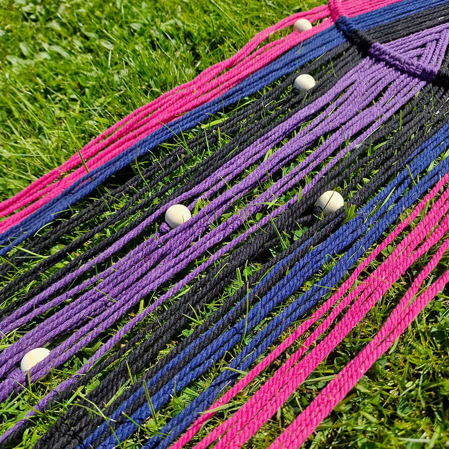 Handcrafted geometric macramé wall hanging in purple, pink, blue and black colours with beads for boho décor