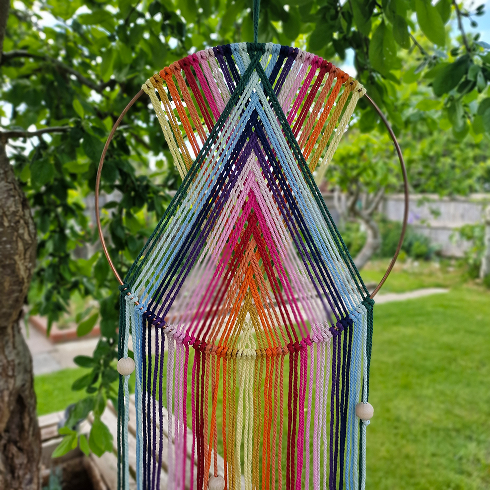 Handcrafted geometric macramé wall hanging in rainbow colours (Red, Yellow, Orange and Green) with beads for boho décor
