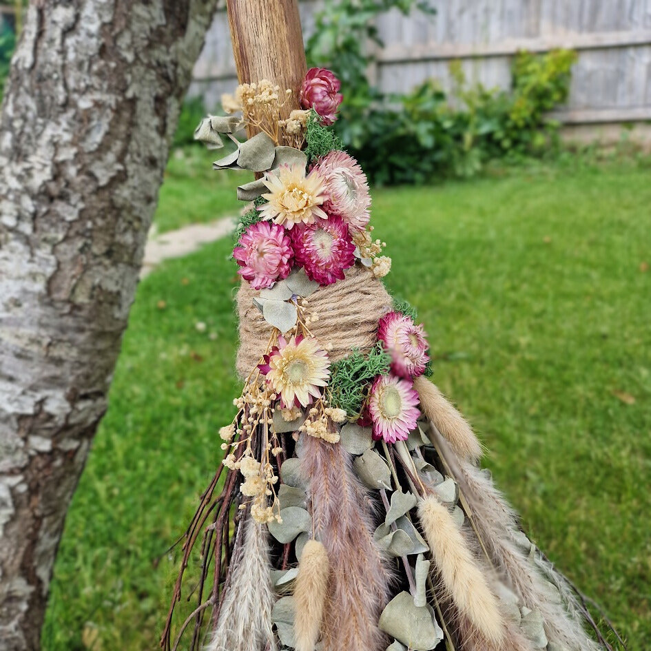 Rustic handmade Pagan witch’s broom with Citrine crystal in the handle, adorned with dried flowers, eucalyptus, and natural twigs.