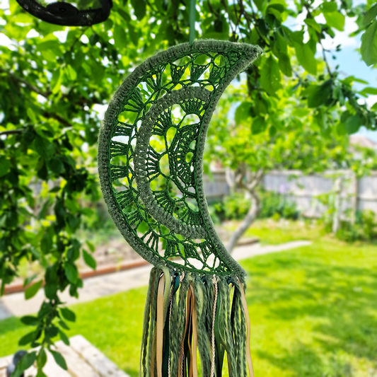 Handmade crochet Moon dreamcatcher with green and gold ribbons and fringe, perfect for boho wall décor and nursery spaces.
