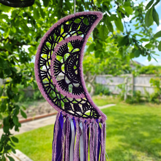 Handmade crochet Moon dreamcatcher with purple and pink ribbons and fringe, perfect for boho wall décor and nursery spaces.