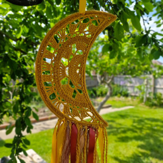 Handmade crochet Moon dreamcatcher with yellow and burnt orange and fringe, perfect for boho wall décor and nursery spaces.
