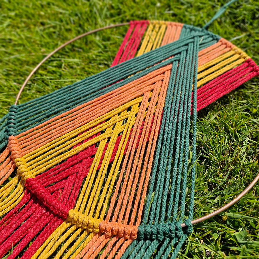 Handcrafted geometric macramé wall hanging in Autumnal colours (Red, Yellow, Orange and Green) with beads for boho décor